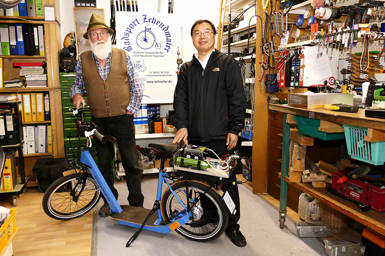 Franz Zehendmair und Wolfgang Chen präsentieren den Elektroroller mit Brennstoffzellen-Antrieb in der Werkstatt von Radsport Zehendmaier